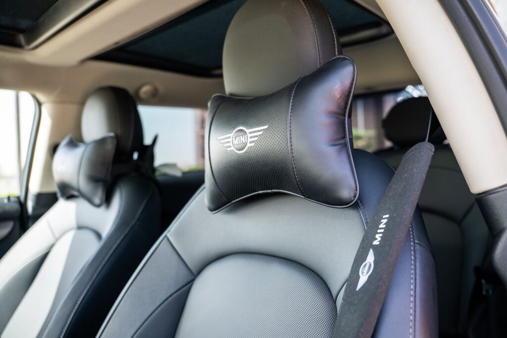 Interior of a modern car with plush leather seats and branded headrest, offering a luxurious driving experience.
